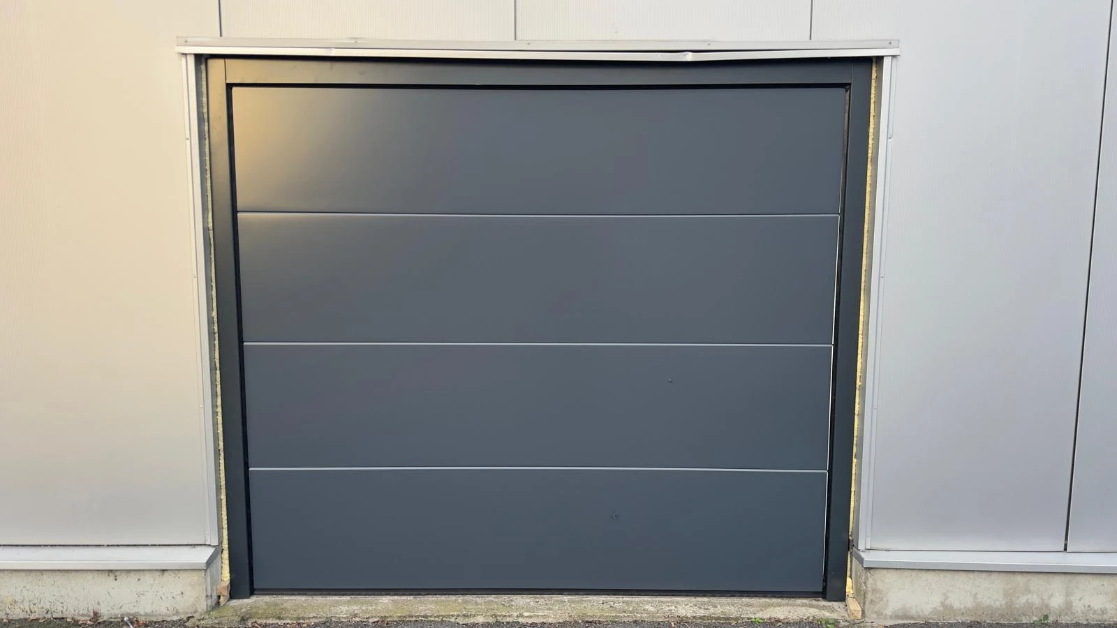 Chantier — porte de garage sectionnelle motorisée sur bâtiment professionnel