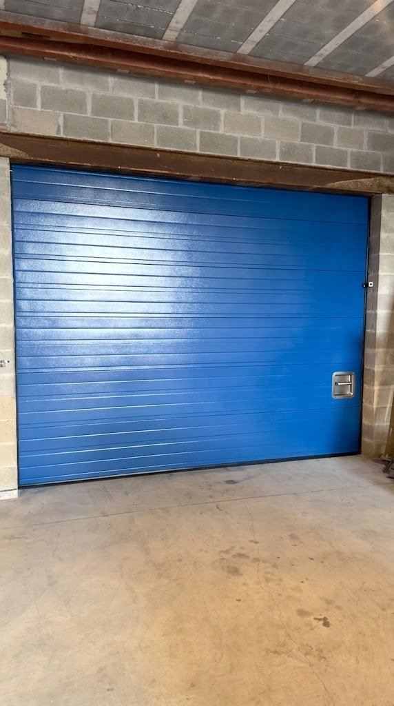 Porte sectionnelle industrielle bleue posée par Rovéo Châssis